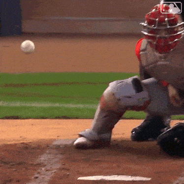a baseball player is getting ready to catch a ball while wearing a helmet