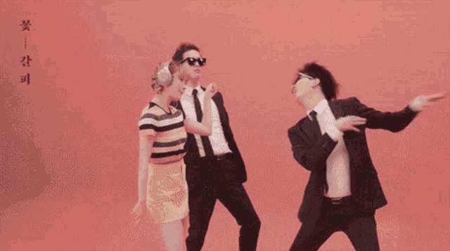 a man in a suit and tie is dancing with two other men