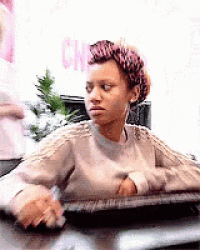 a woman is sitting at a desk with her arms crossed and a leopard print headband on her head .