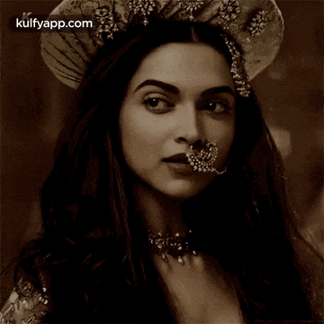 a black and white photo of a woman wearing a nose ring and a crown