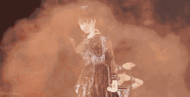 a woman in a black dress is standing in front of a microphone with smoke coming out of her mouth .