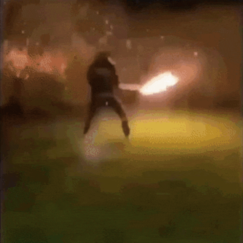 a blurry picture of a person standing in front of a fire