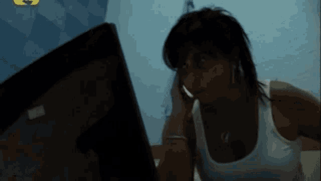 a woman talking on a cell phone while looking at a monitor