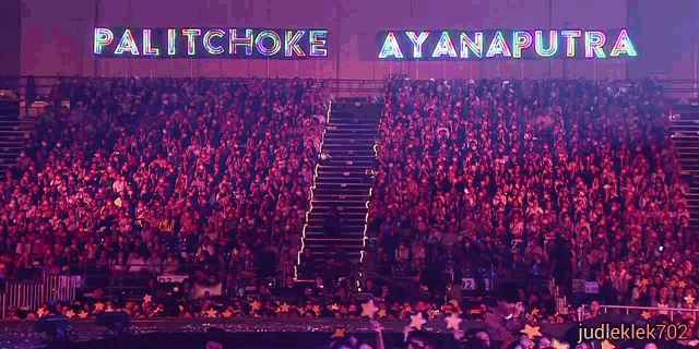 a crowd of people in a stadium with a sign that says palitchoke ayanputra on it