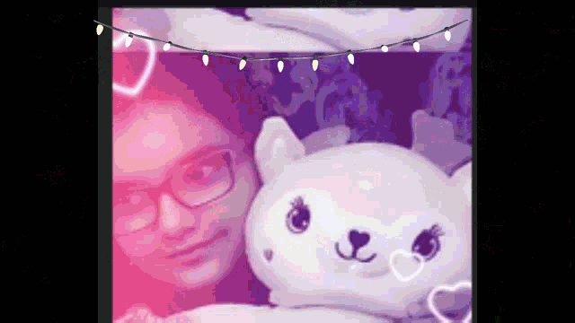 a girl with glasses is holding a stuffed animal in front of her face
