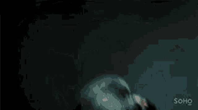 a close up of a person 's face in the dark with a ghost coming out of it .