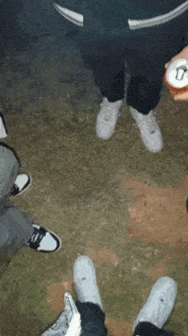 a group of people are standing in a circle holding cans of soda