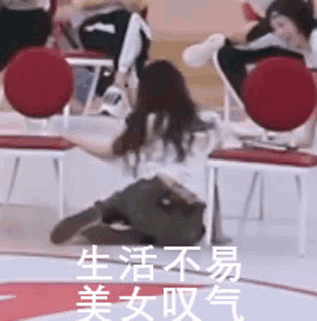 a woman is kneeling on the floor in front of a crowd of people sitting in chairs .