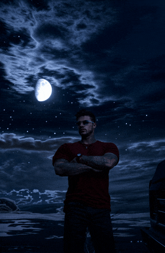 a man stands in front of a full moon