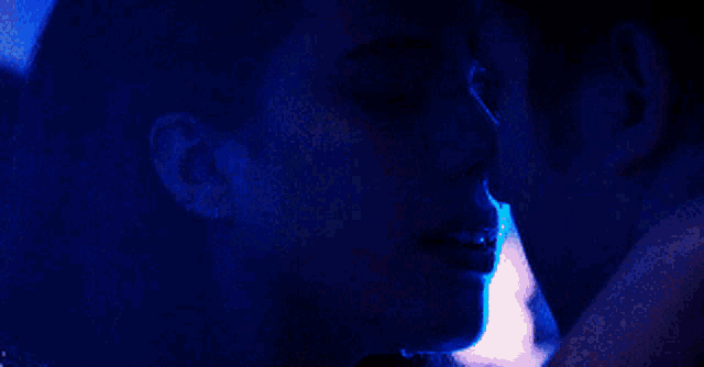 a close up of a woman 's face with a man 's face in the background .
