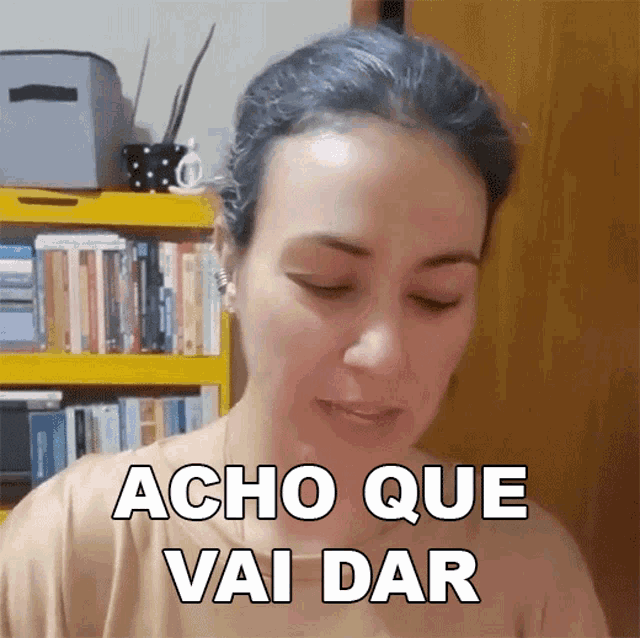 a woman says acho que vai dar in front of a bookcase
