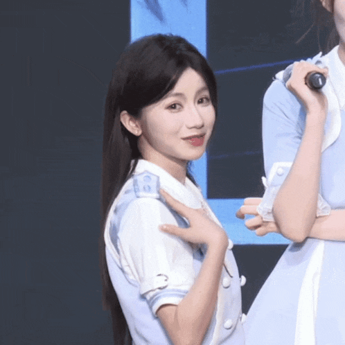a girl in a blue dress holds a microphone