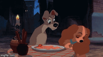 a couple of cartoon dogs sitting at a table with a plate of spaghetti ..