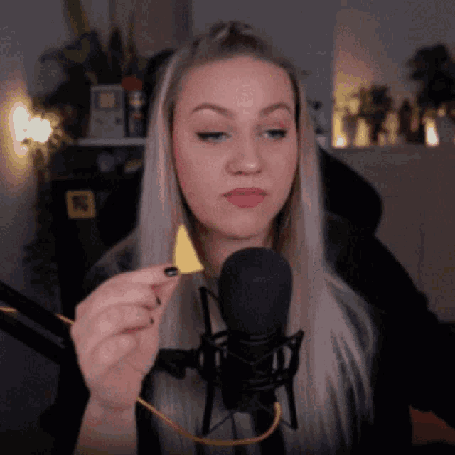 a woman in front of a microphone is holding a piece of paper