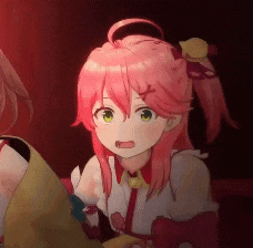 a girl with pink hair and green eyes is sitting next to another girl in a dark room .