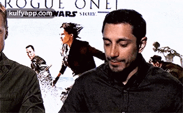a man stands in front of a rogue one poster