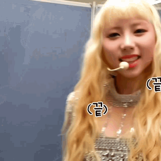 a woman with blonde hair is wearing a microphone