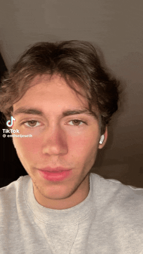 a close up of a young man 's face with a tiktok sticker on it