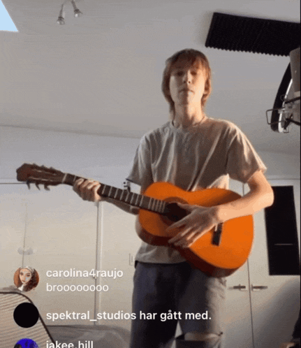 a young man playing a guitar with the words spektral_studios har gått med