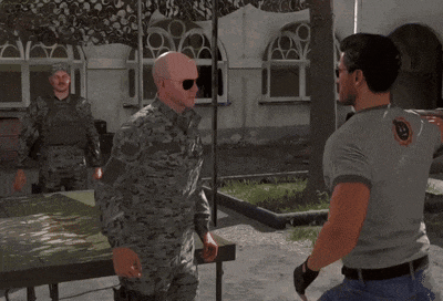 a man in a military uniform is standing next to another man in a gray shirt