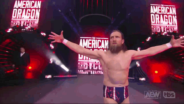 a bearded wrestler is standing in front of a banner that says american dragon