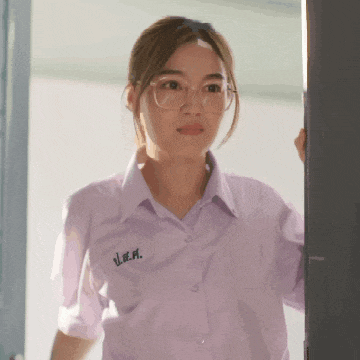 a girl wearing glasses and a purple shirt with the letter m on the sleeve
