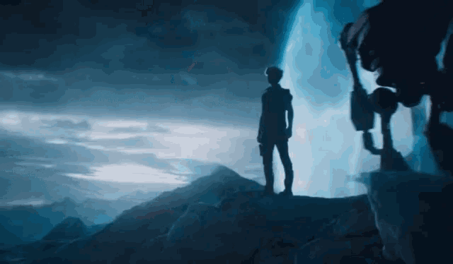 a silhouette of a person standing on top of a hill