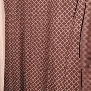a close up of a brown and white shower curtain with a geometric pattern .