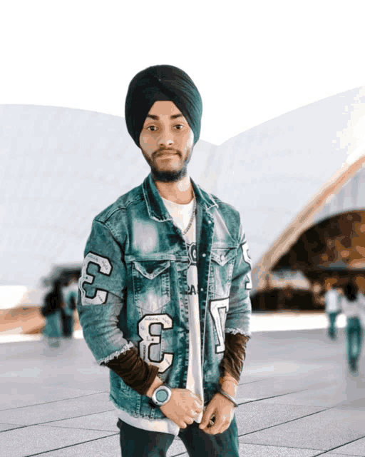 a man wearing a turban and a denim jacket with the numbers 33 on it