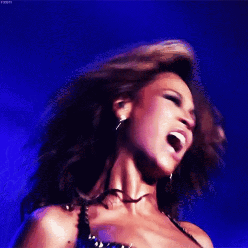 a close up of a woman singing on a stage
