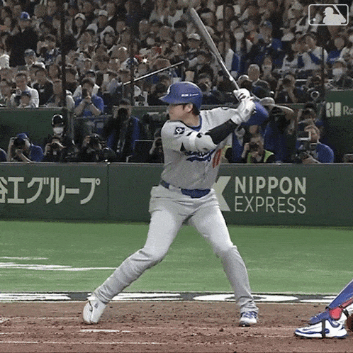 a baseball player is swinging at a pitch in front of a banner for nippon express