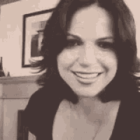 a black and white photo of a woman smiling
