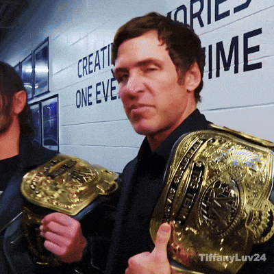 a man is holding a wrestling belt in front of a wall that says " create one eve "