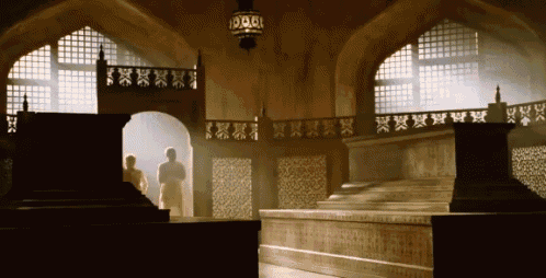 a very ornate room with a staircase and a lantern hanging from the ceiling and a few windows