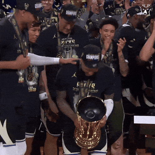 a man holding a trophy with the word champions on it
