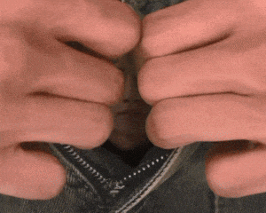a close up of a person 's hands opening a zipper on a pair of jeans