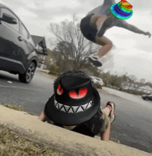 a person wearing a black hat with red eyes is laying on the side of the road