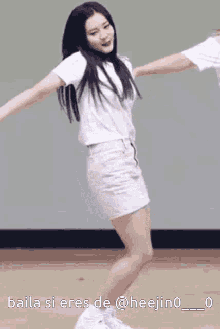 a woman in a white shirt and white shorts is dancing with the caption baila si eres de @heejino_0_0