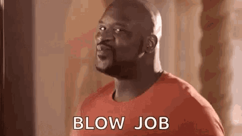 a man in a red shirt is blowing a kiss .