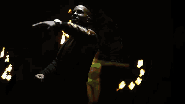 a man in a kappa jacket is standing in front of a fire show
