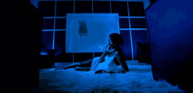 a woman is laying on a blue rug in front of a screen that says ' 00 ' on it