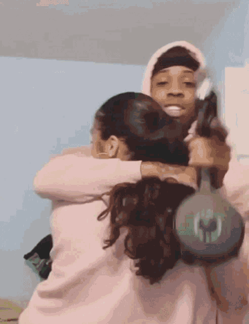 a man is hugging a woman while holding a gun in his hand .