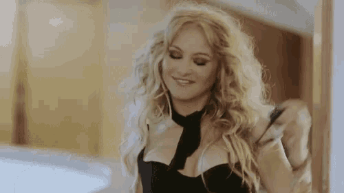 a woman with long blonde hair is wearing a black top and a black tie .
