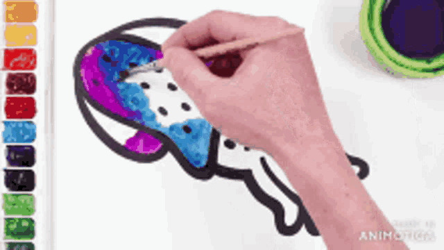 a person is painting a jellyfish on a white paper