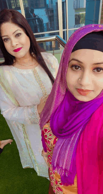 two women posing for a picture one wearing a purple scarf