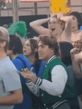a man in a green jacket is dancing in a crowd of people