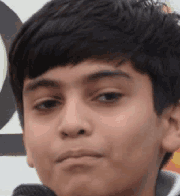 a close up of a child 's face with a serious look on his face