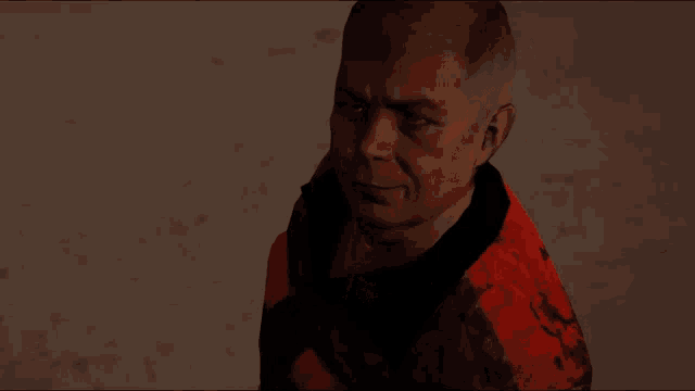 a man in a red and black jacket is looking at something