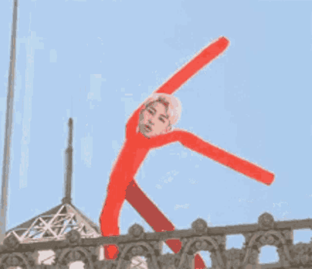 a statue of a man in a red suit is on a balcony