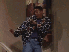 a man in a polka dot shirt is standing on a set of stairs holding a painting .
